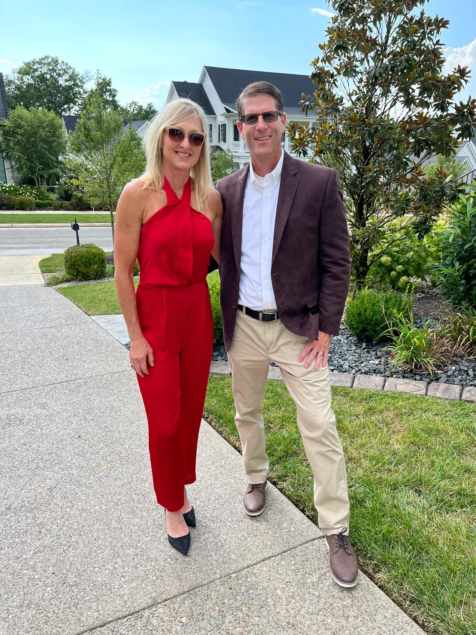 Kristin and Terry McCarthy, the owners of Nashville Home Pros Magazine, standing on a sidewalk in front of a Nashville-area home